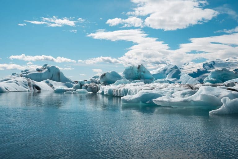 Panorama sulla laguna glaciale di Jökulsárlón, con vari iceberg enormi che galleggiano e si riflettono sull'acqua